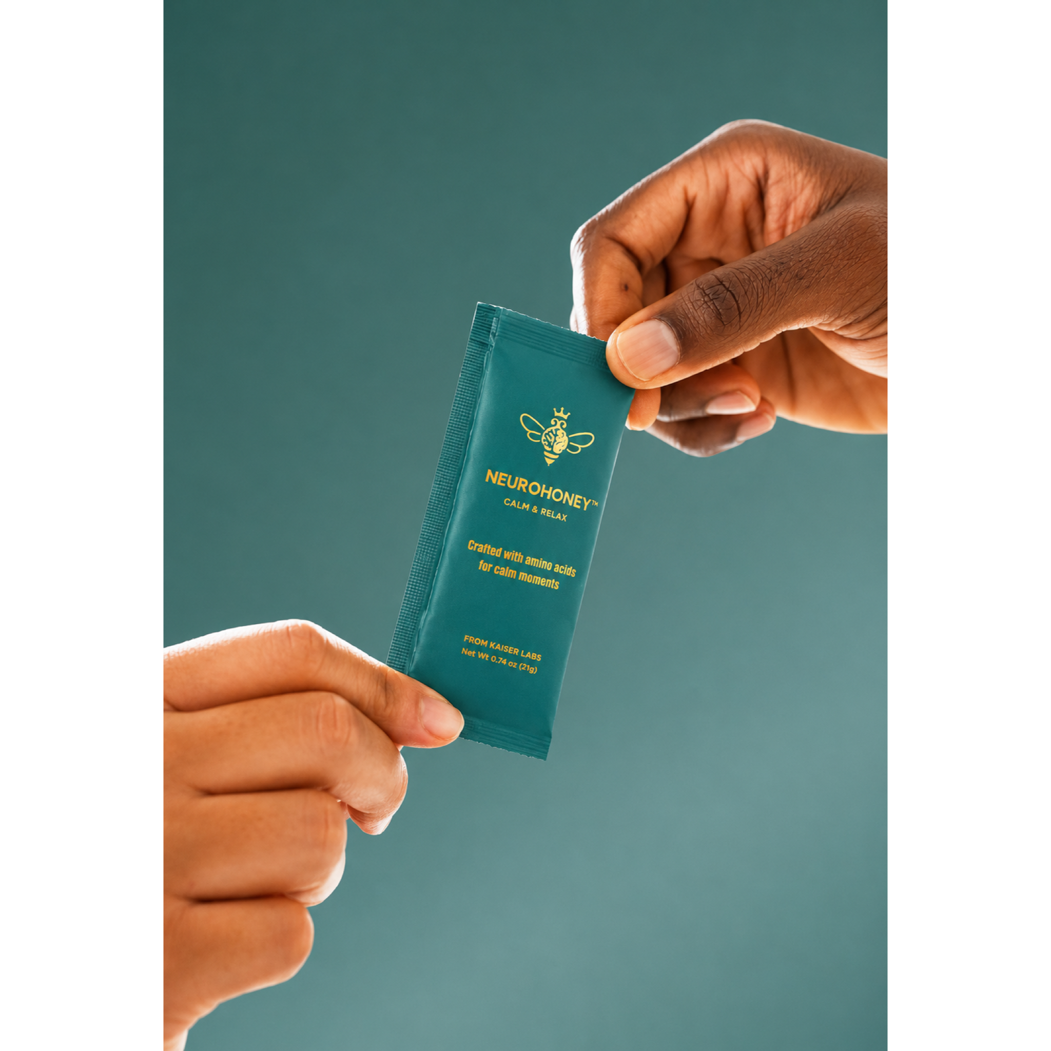 Two hands holding a small teal Neurohoney Calm & Relax packet against a solid teal background.